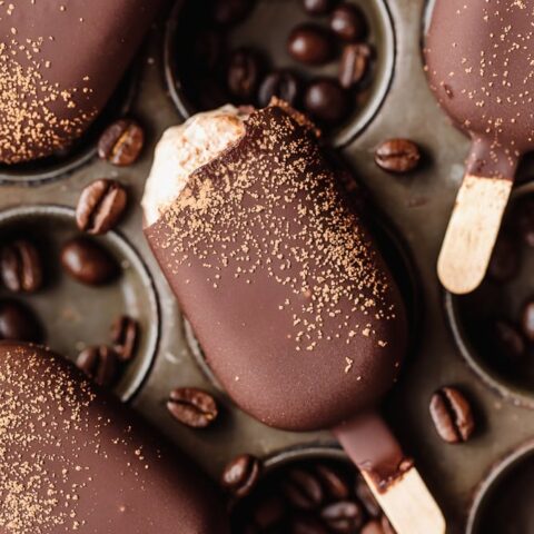 Chocolate popsicles with coffee beans and gold dust, close-up.