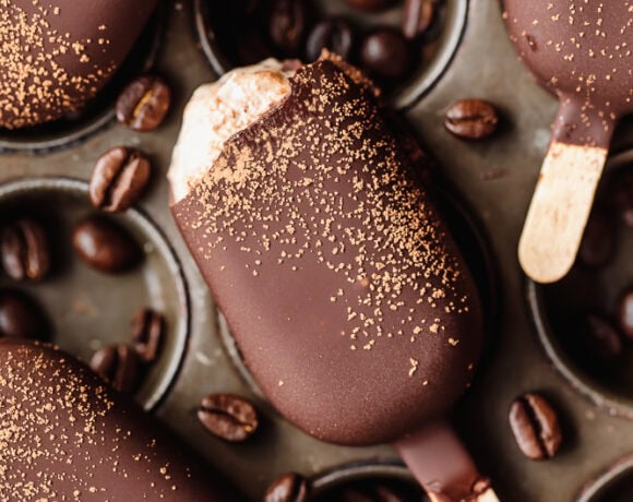 Chocolate popsicles with coffee beans and gold dust, close-up.