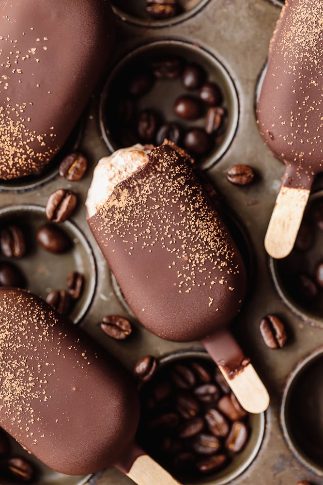 Chocolate popsicles with coffee beans and gold dust, close-up.