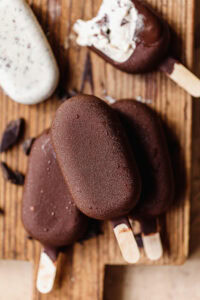 Chocolate and vanilla ice cream bars on wooden surface.