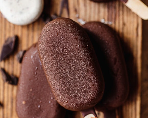 Chocolate and vanilla ice cream bars on wooden surface.