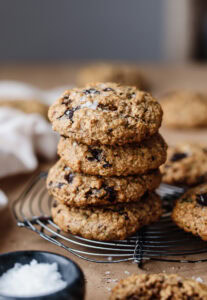 Stack of freshly baked chocolate chip cookies on a cooling rack.